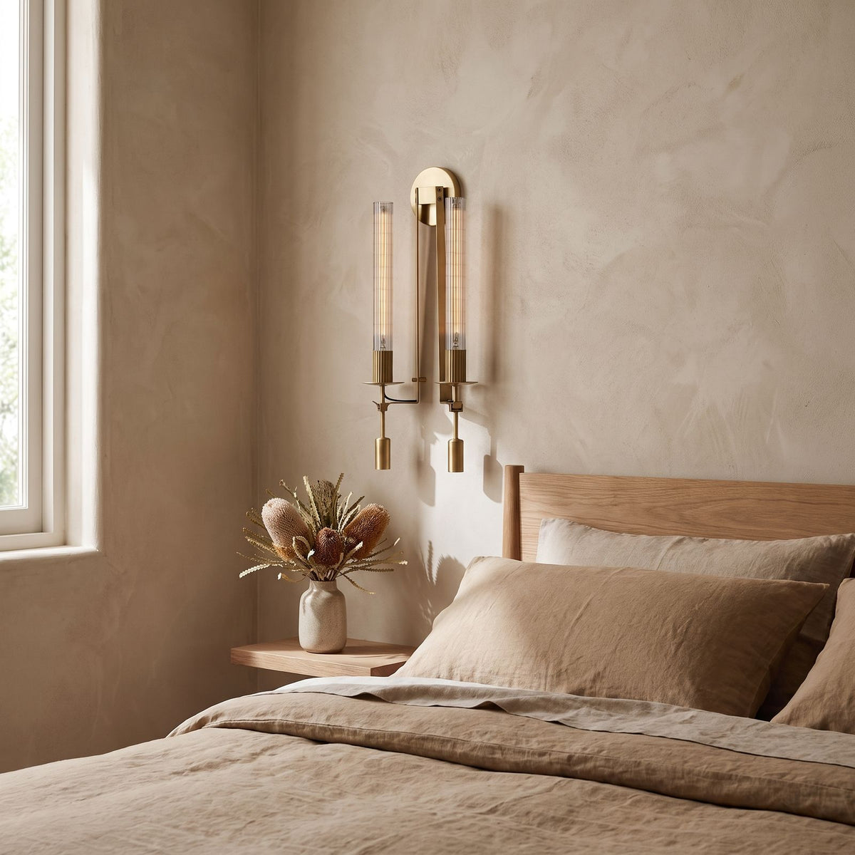 Tall Ribbed Glass and Brass Column Wall Light on a bedroom wall beside the bed