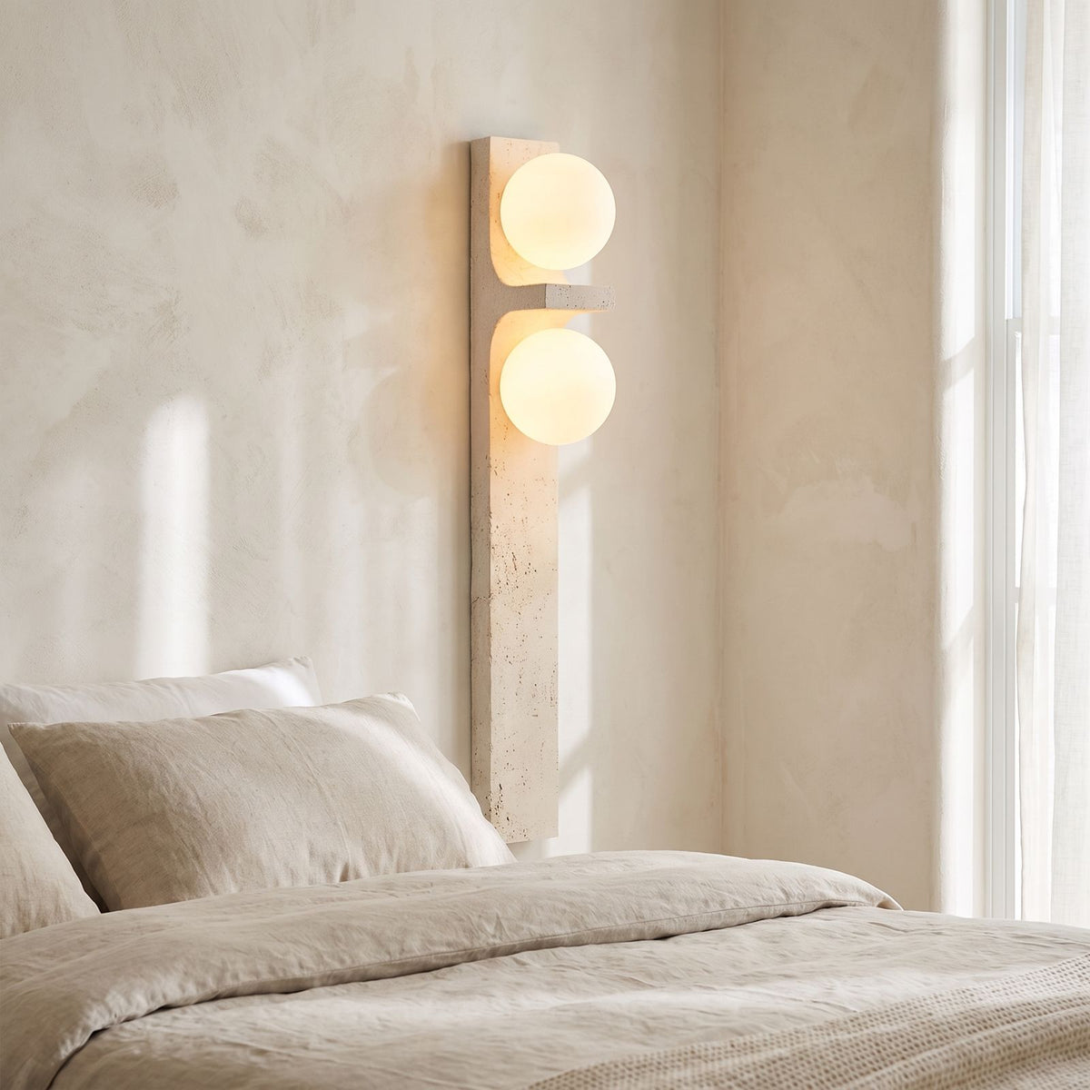 Tall Slim Travertine Strip Wall Light on a bedroom wall beside the bed