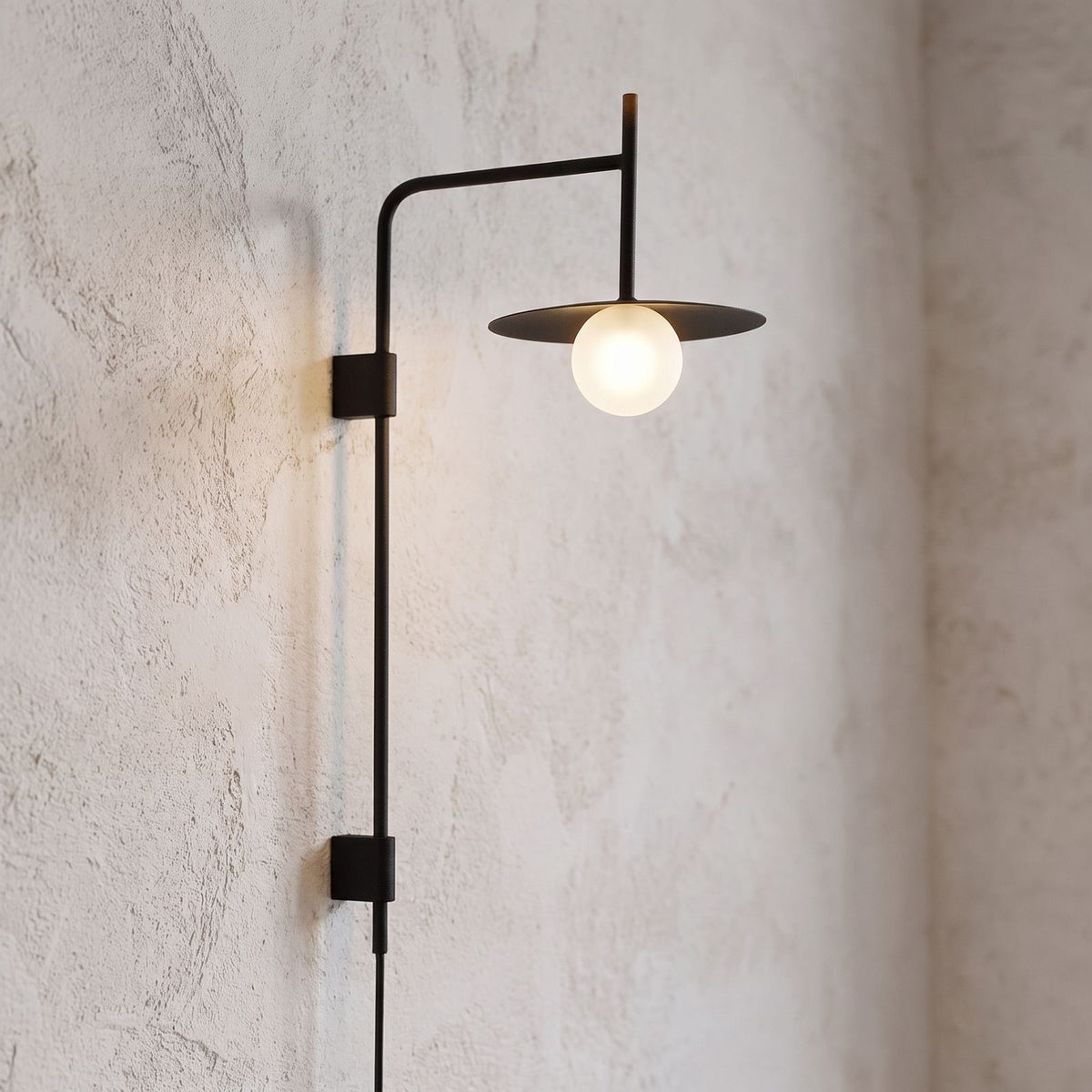 Tall Swing Arm Globe Plug-In Wall Light, close view at 45 degrees on a plaster wall