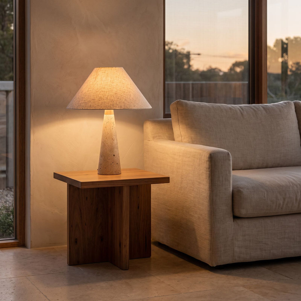 Tapered Travertine Stem Table Lamp on a side table beside a sofa