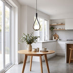 Teardrop frame glass globe pendant light over a small kitchen table in daylight
