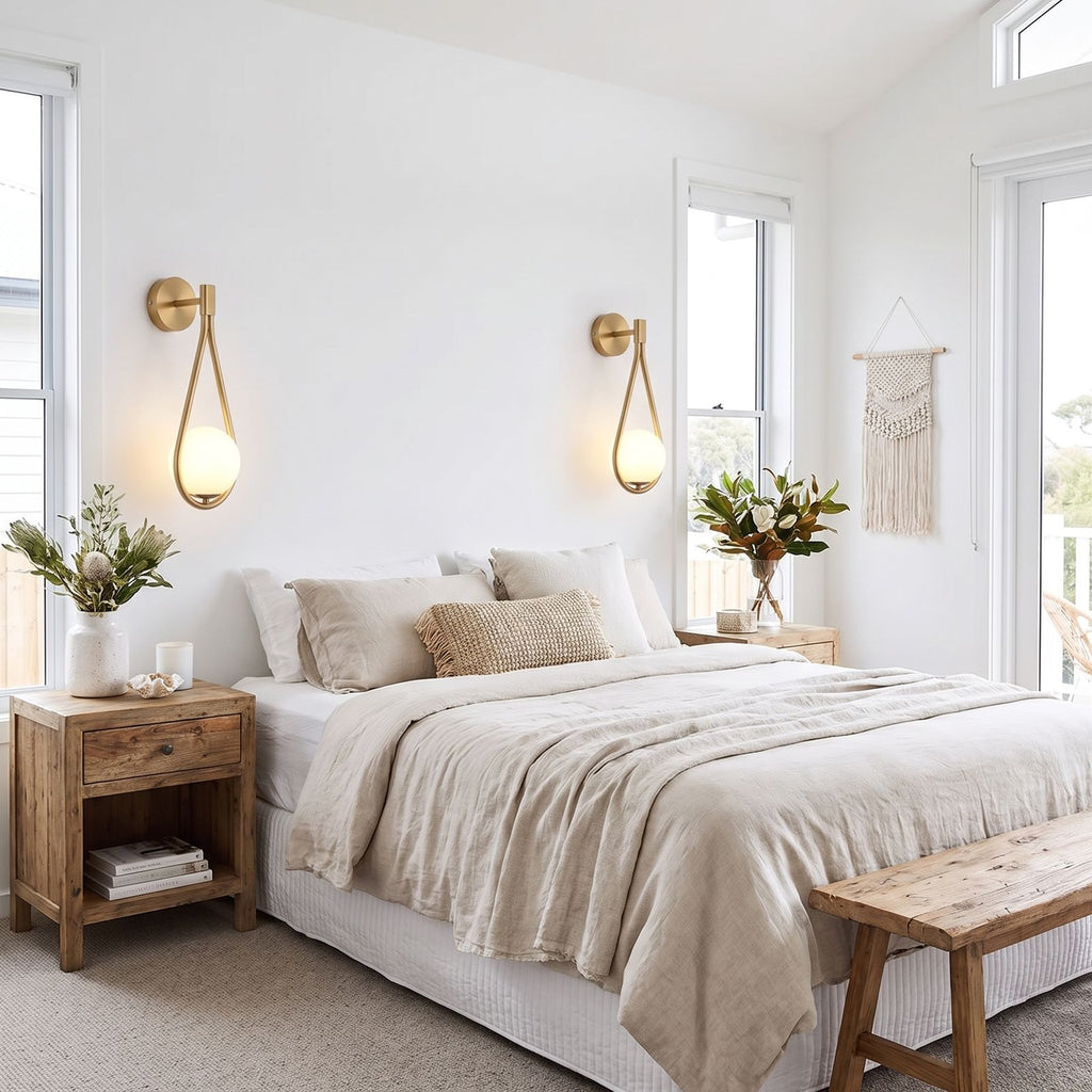 Teardrop Gold Frame Opal Glass Globe Wall Light pair either side of a bed in a coastal bedroom in daylight
