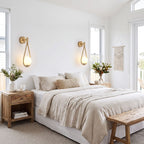 Teardrop Gold Frame Opal Glass Globe Wall Light pair either side of a bed in a coastal bedroom in daylight