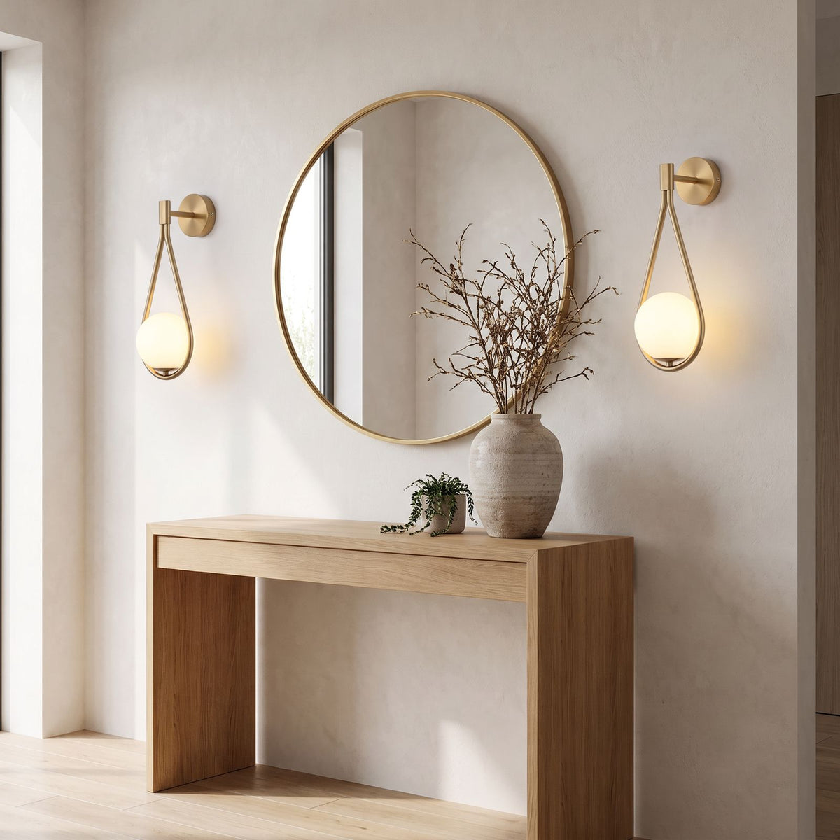 Teardrop Gold Frame Opal Glass Globe Wall Light pair either side of a round mirror above an oak console in an entrance hall