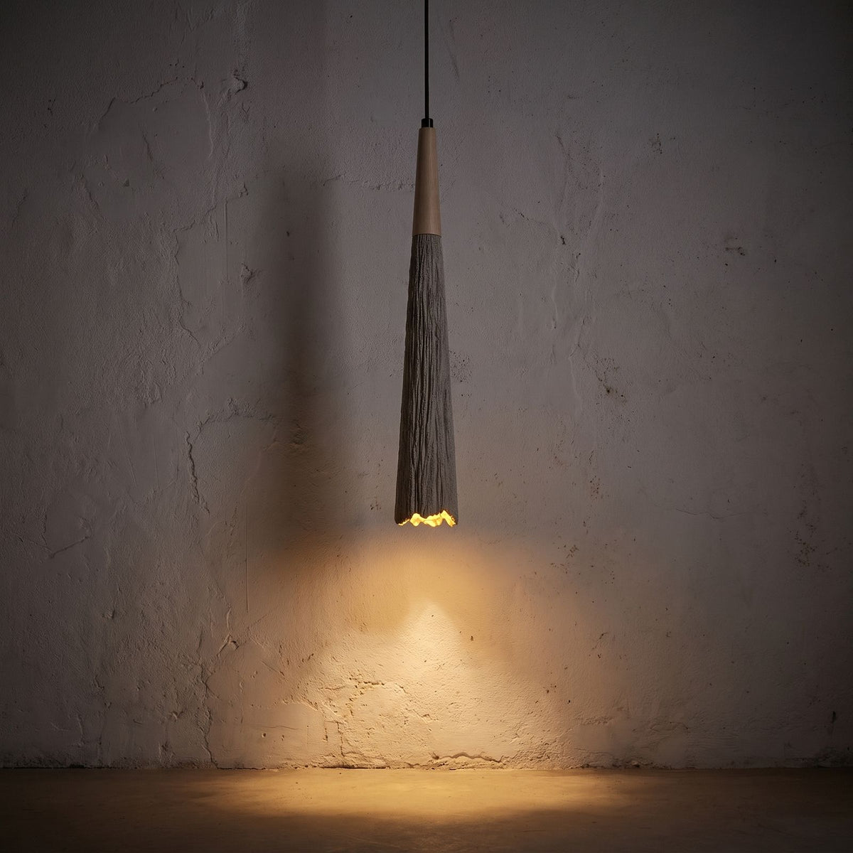Textured Cement Cone Pendant Light glowing against a plaster wall at night