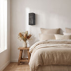 Textured Cement-Finish Box Wall Light on a bedroom wall beside the bed