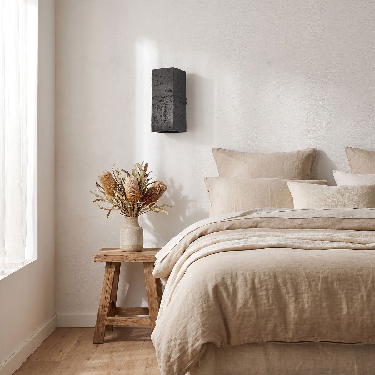 Textured Cement-Finish Box Wall Light on a bedroom wall beside the bed