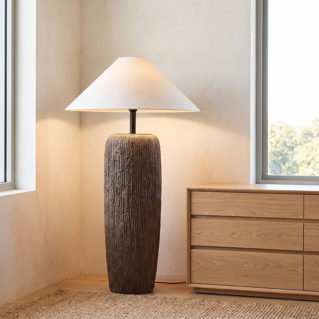 Textured clay base cone shade floor lamp in a bedroom corner in daylight