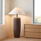 Textured clay base cone shade floor lamp in a bedroom corner in daylight