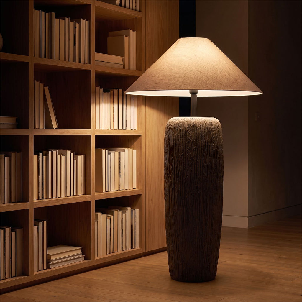 Textured clay base cone shade floor lamp in a reading corner at night