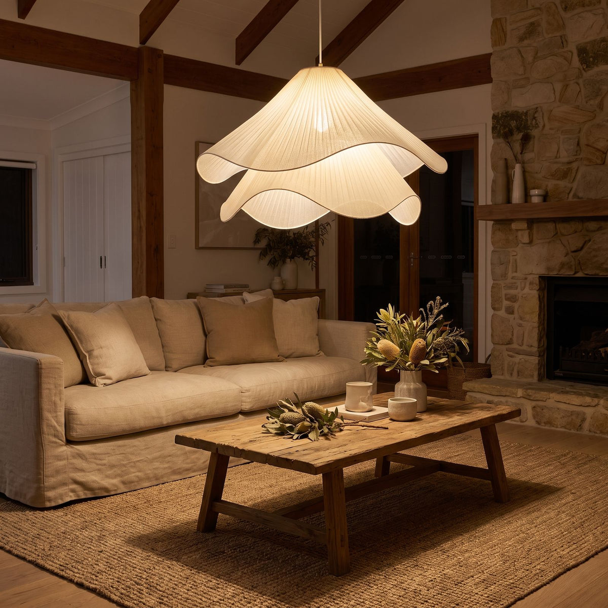 Tiered pleated fabric pendant light over a living room coffee table