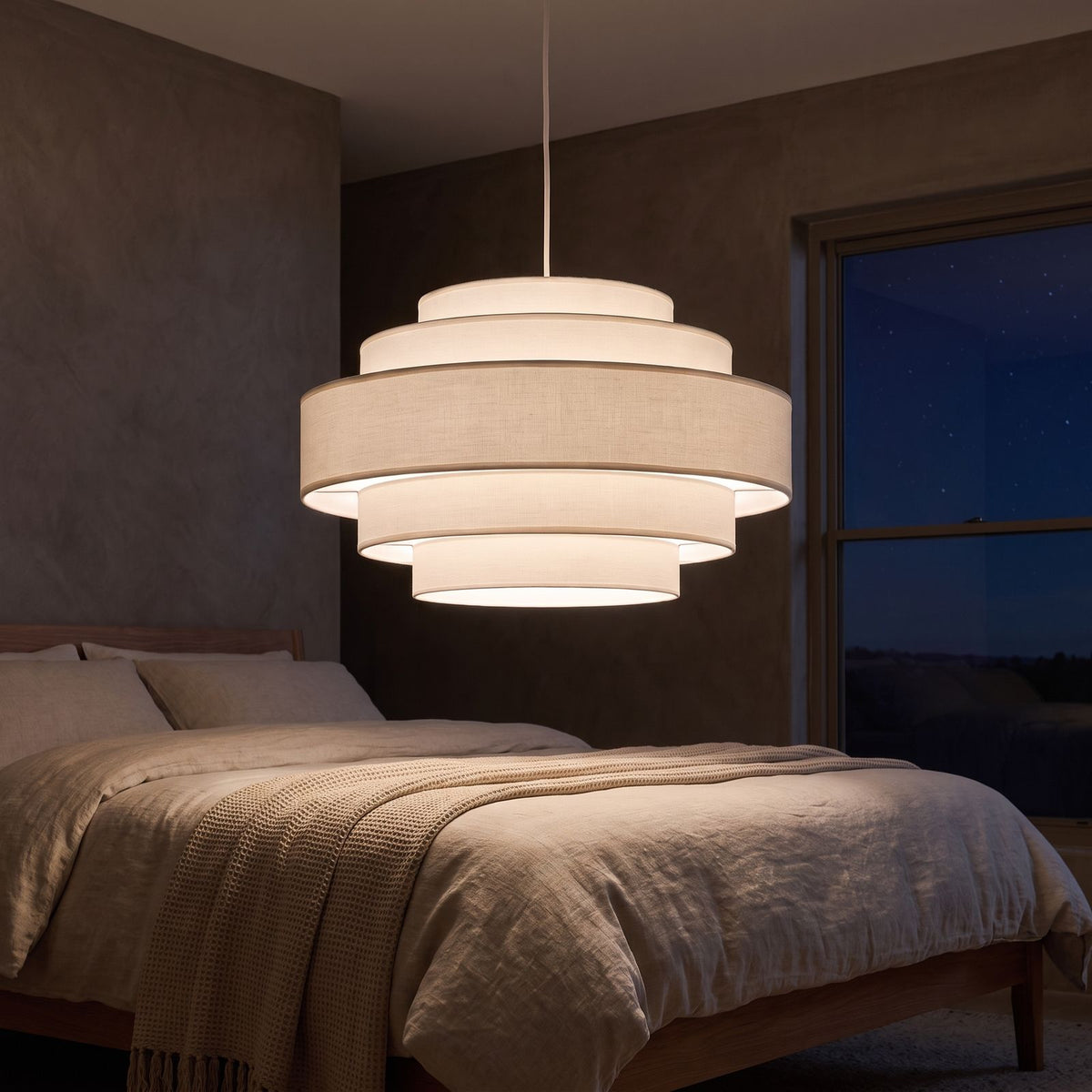 Tiered white drum LED pendant light in a bedroom at night