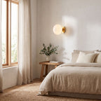Tinted Glass Ball Up and Down Wall Light on a bedroom wall beside the bed