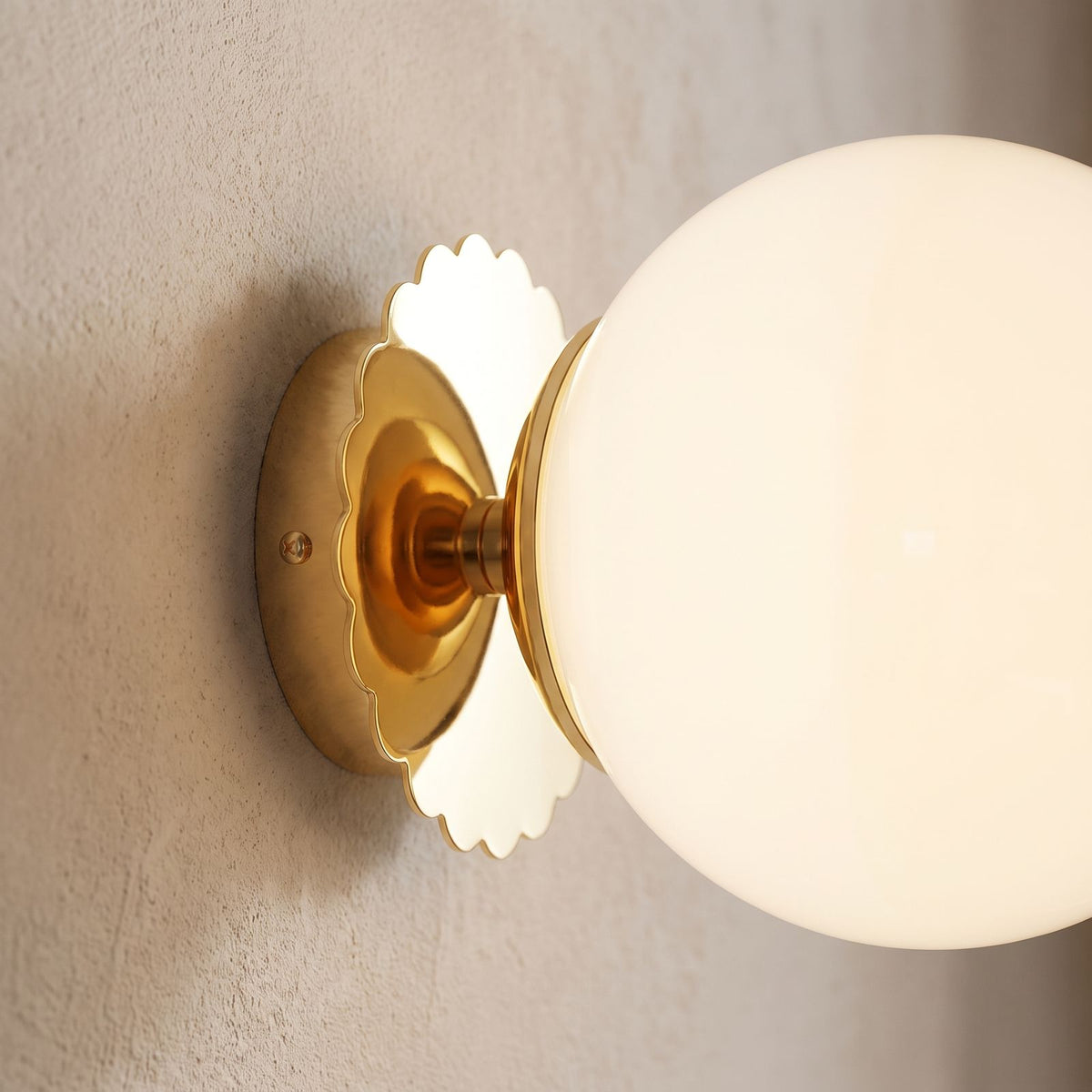 Tinted Glass Ball Up and Down Wall Light, close view at 45 degrees on a plaster wall