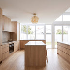 Tinted glass bowl semi-flush ceiling light in a wide hallway view
