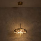 Tinted Glass Capsule and Globe Pendant Light glowing against a plaster wall at night