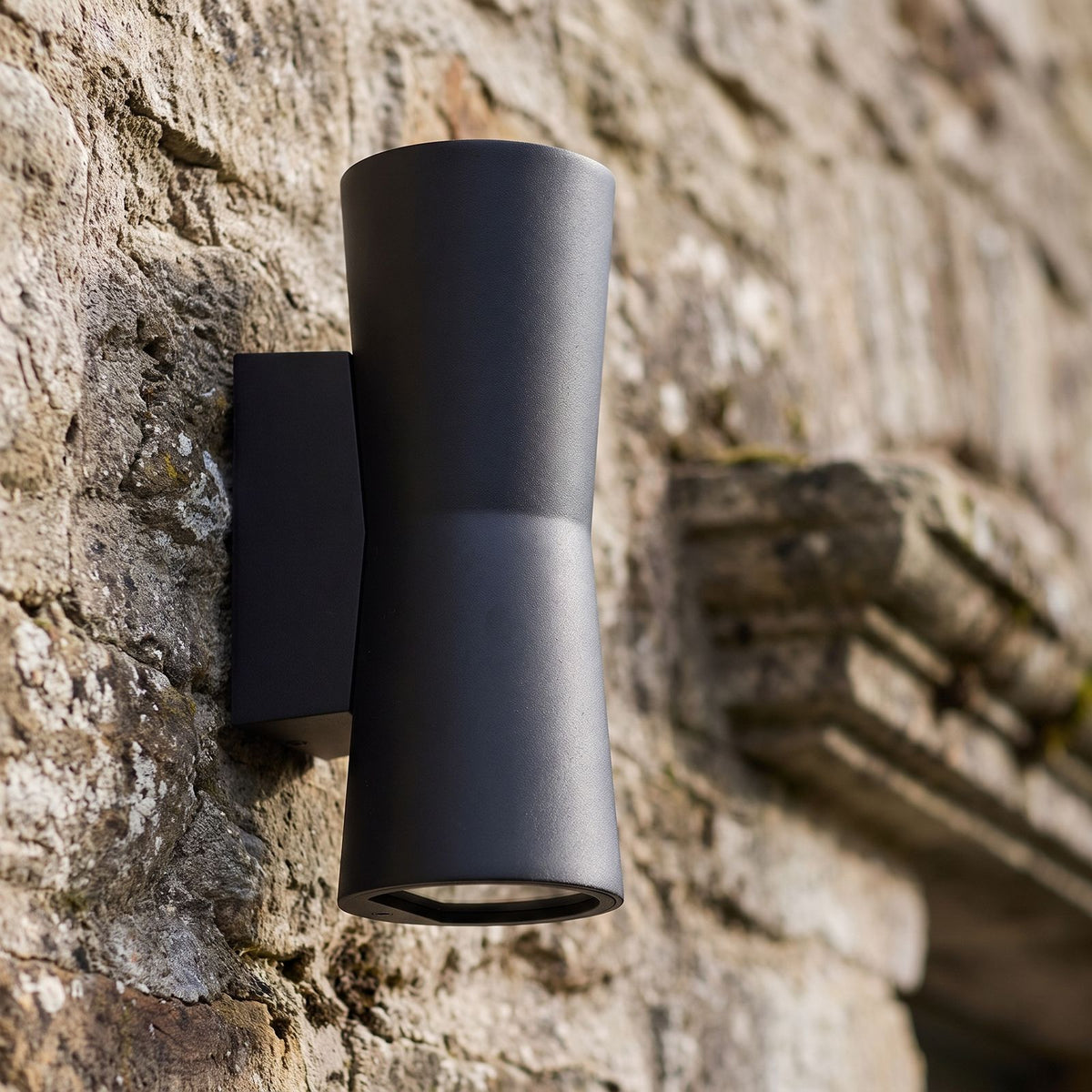 Torch Shape Acrylic Up Down Outdoor Wall Light, close view at 45 degrees on a stone wall