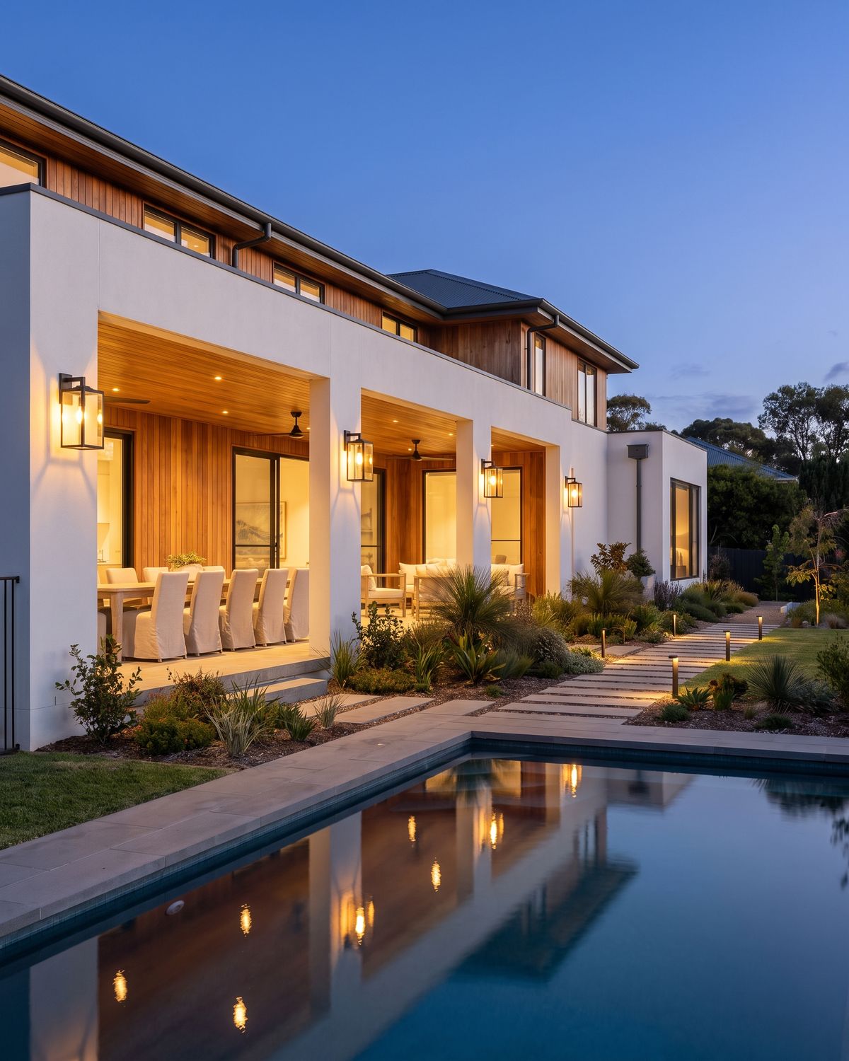 Outdoor wall lanterns lit along the alfresco of a contemporary Australian home at dusk