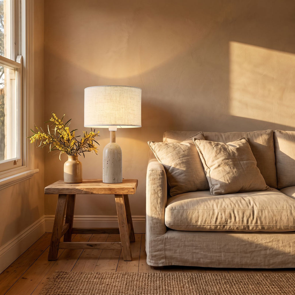 Travertine Base Fabric Shade Table Lamp on a side table beside a sofa