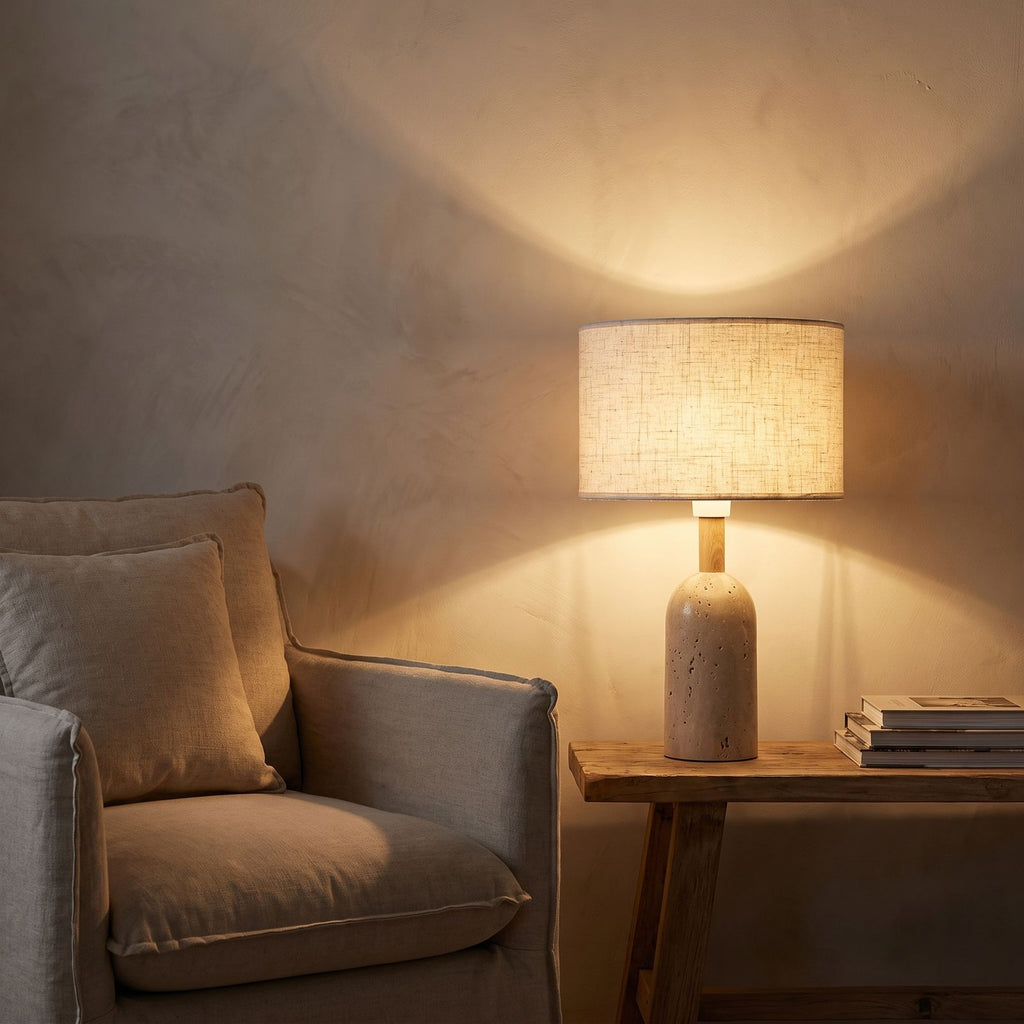 Travertine Base Fabric Shade Table Lamp beside a reading armchair