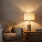 Travertine Base Fabric Shade Table Lamp beside a reading armchair