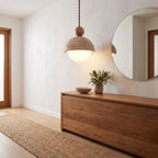 Travertine dome and glass globe pendant light above an entry hall console