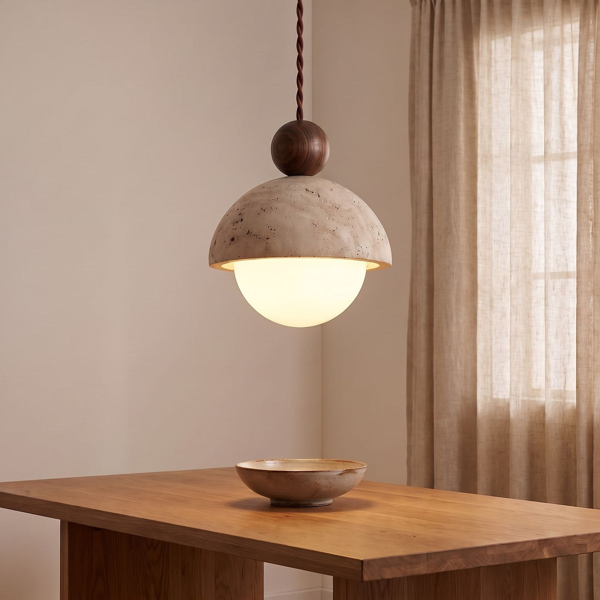 Travertine Dome and Glass Globe Pendant Light with a walnut ball above a dining table