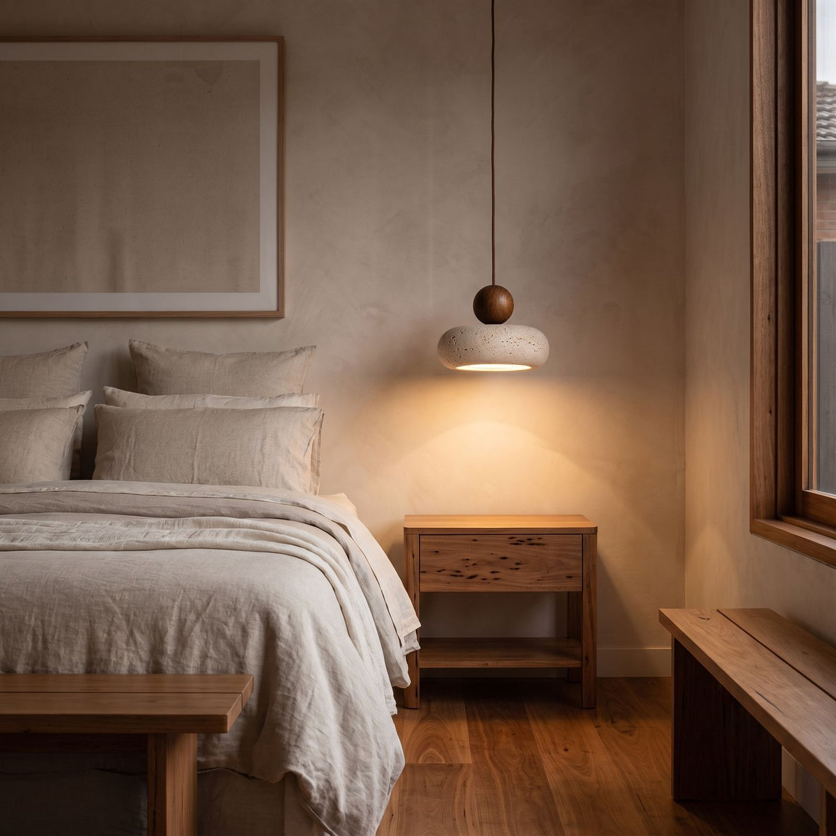 Travertine Donut and Wood Ball Pendant Light hanging beside a bed