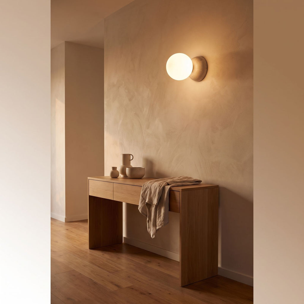 Travertine Half Dome Glass Orb Wall Light in a hallway above a timber console