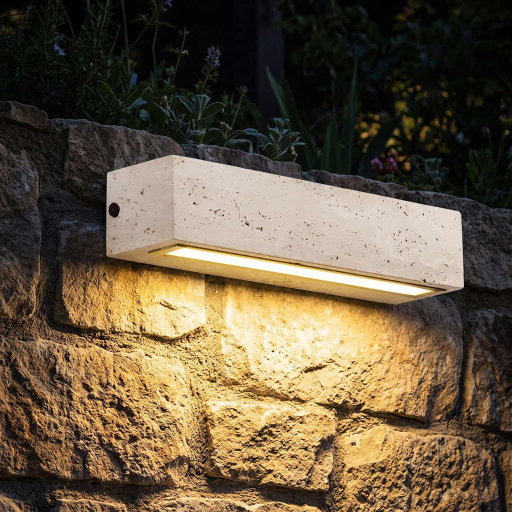 Travertine Look Resin Linear Up Down Outdoor Wall Light glowing on a garden wall at night