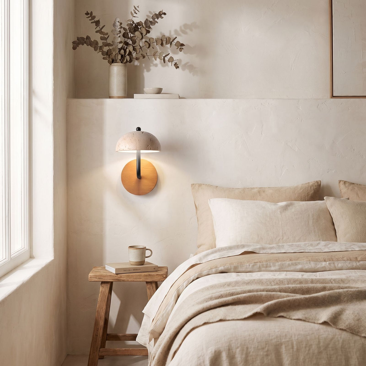 Travertine Mushroom Dome Bedside Wall Light on a bedroom wall beside the bed