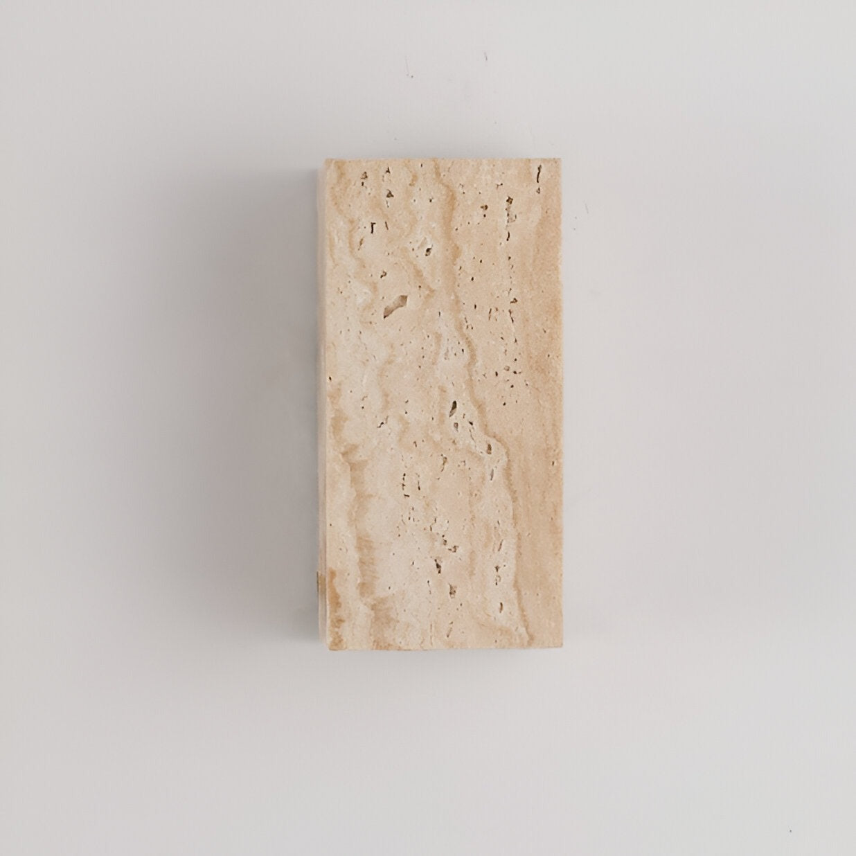 Travertine stone wall light mounted on a pale wall