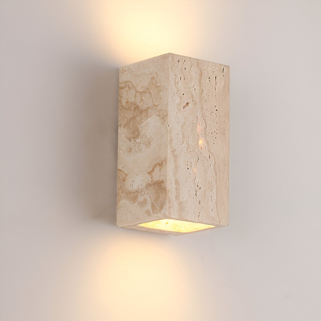 Travertine wall light glowing up and down on a warm wall