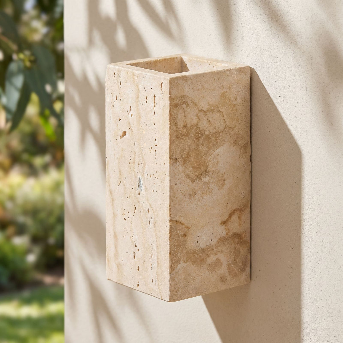 Travertine Stone Outdoor Up Down Wall Light on a rendered wall, angled close view
