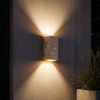 Travertine Stone Outdoor Up Down Wall Light lighting a concrete wall at night