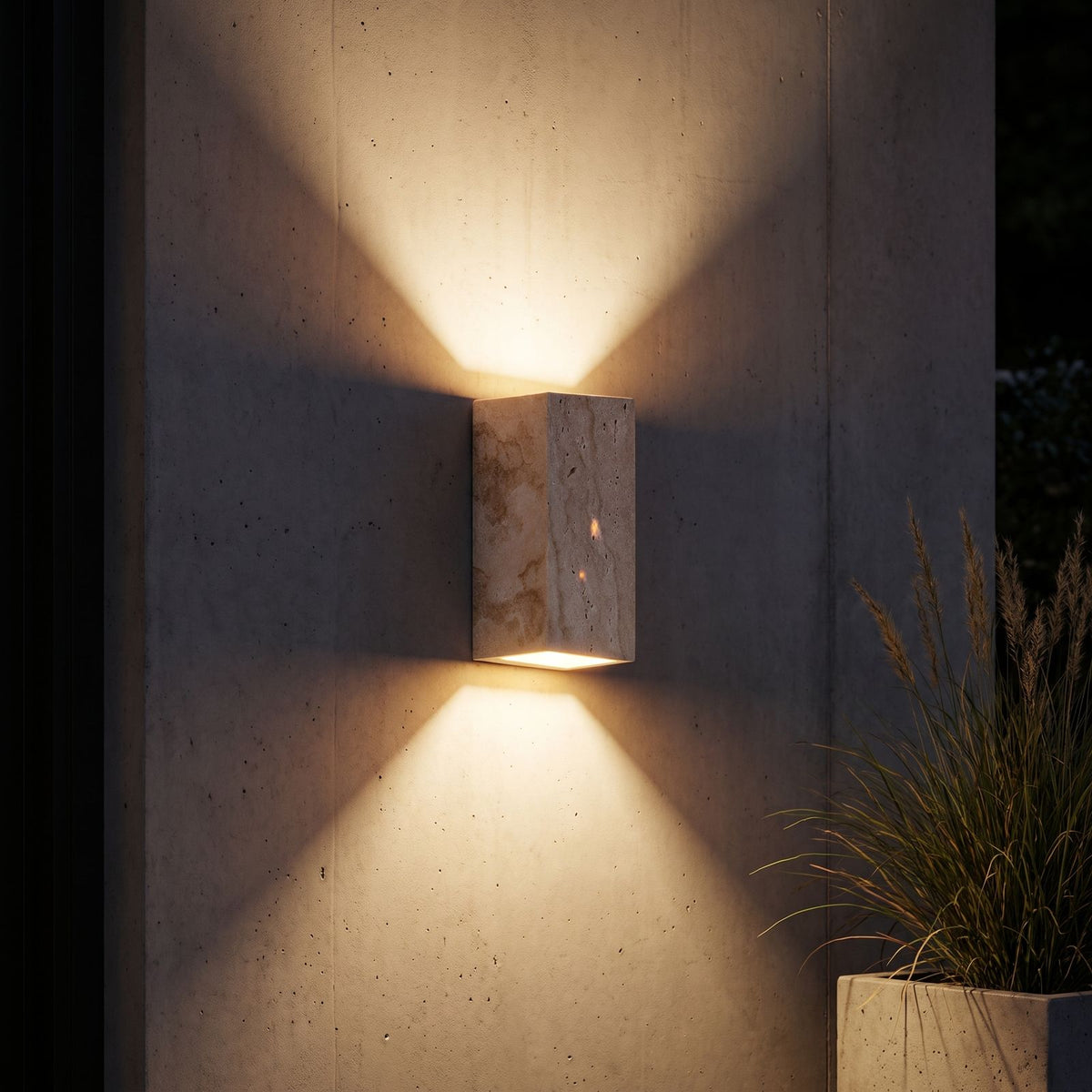 Travertine Stone Outdoor Up Down Wall Light lighting a concrete wall at night