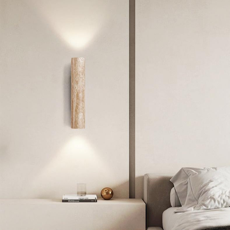 Travertine wall light casting up and down light above a sofa