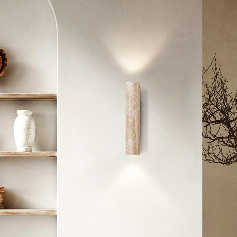 Travertine tube wall light beside a shelf with a vase