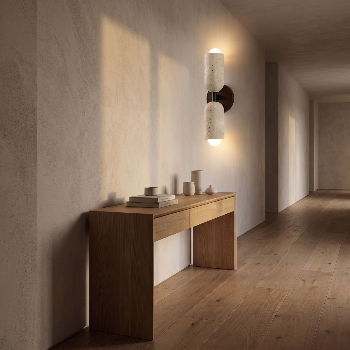 Travertine Up Down LED Wall Sconce with Wood Accent in a hallway above a timber console