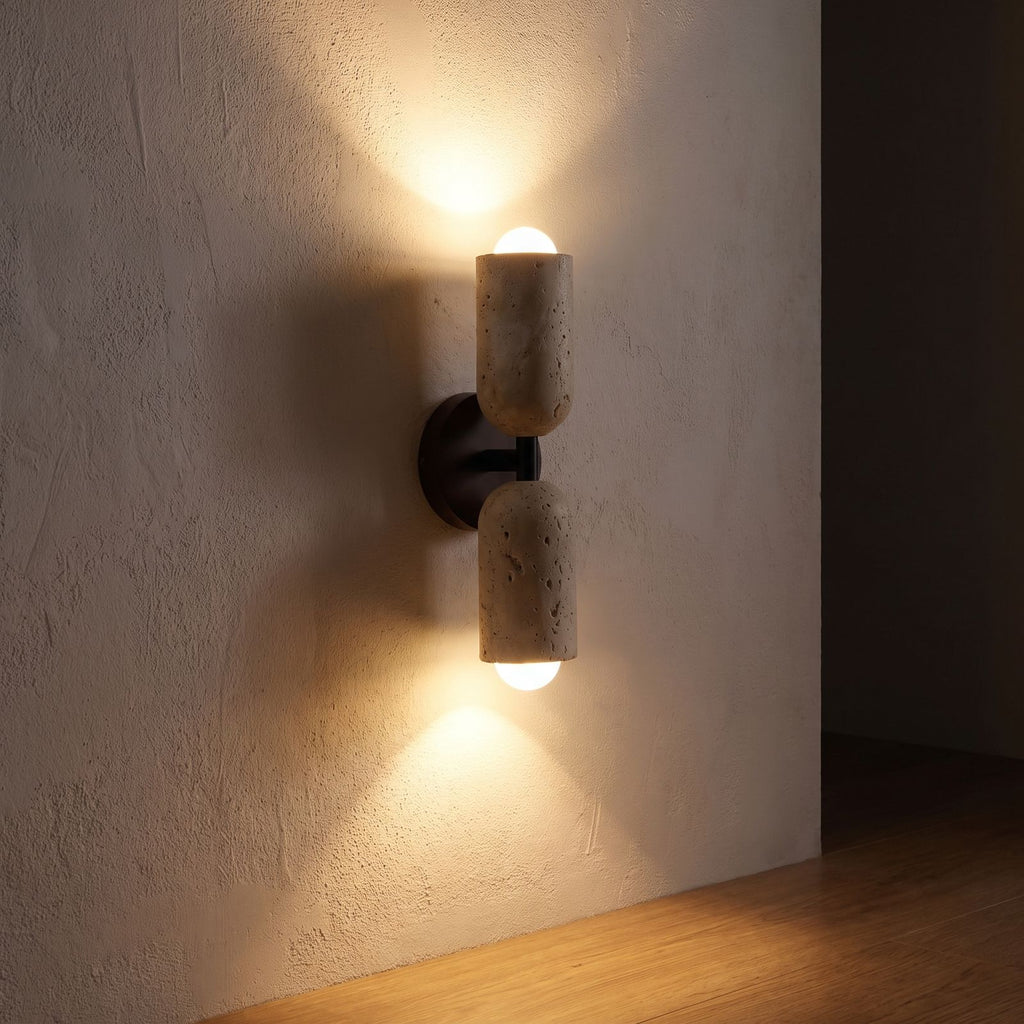 Travertine Up Down LED Wall Sconce with Wood Accent glowing on a plaster wall at night