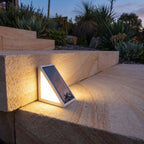 Triangular Alloy Solar Garden Step Light on a sandstone step at dusk