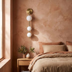 Triple Frosted Glass Orb Vertical Wall Light on a bedroom wall beside the bed