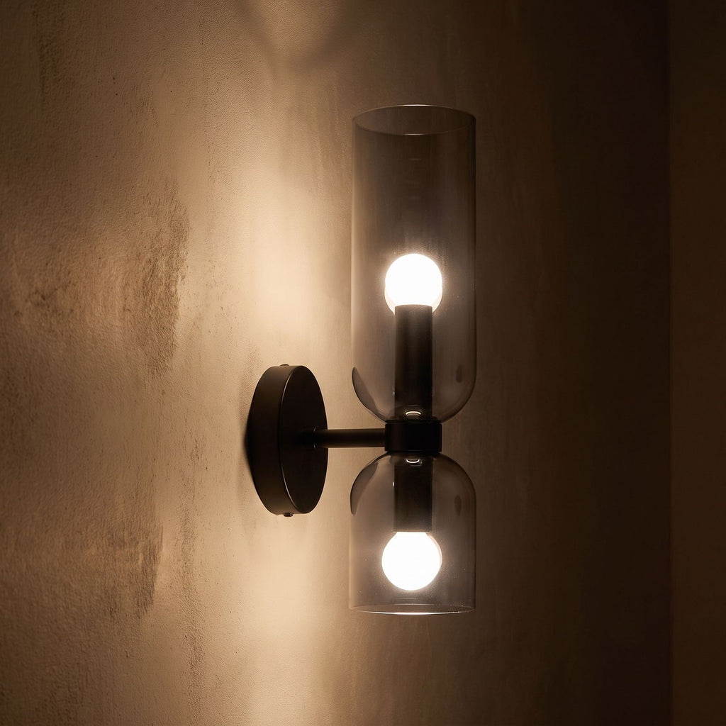 Twin Coloured Glass Shade Wall Light glowing on a plaster wall at night
