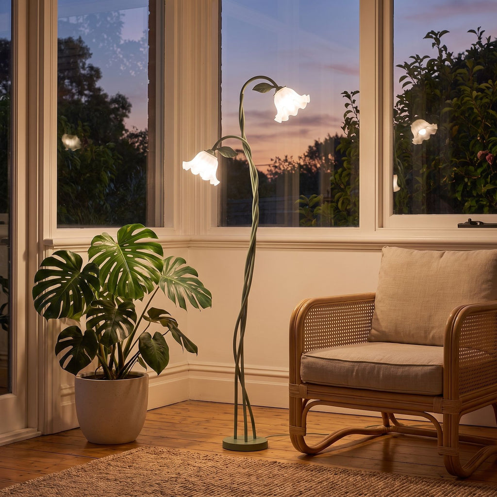 Green stem flower shade floor lamp in a sunroom corner beside a cane chair