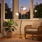 Green stem flower shade floor lamp in a sunroom corner beside a cane chair