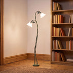 Green stem flower shade floor lamp in a reading corner beside a bookshelf