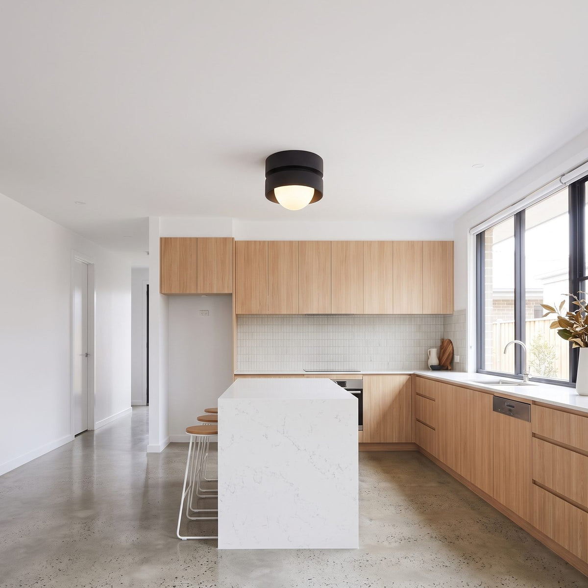 Two-tier resin drum ceiling light in a wide hallway view
