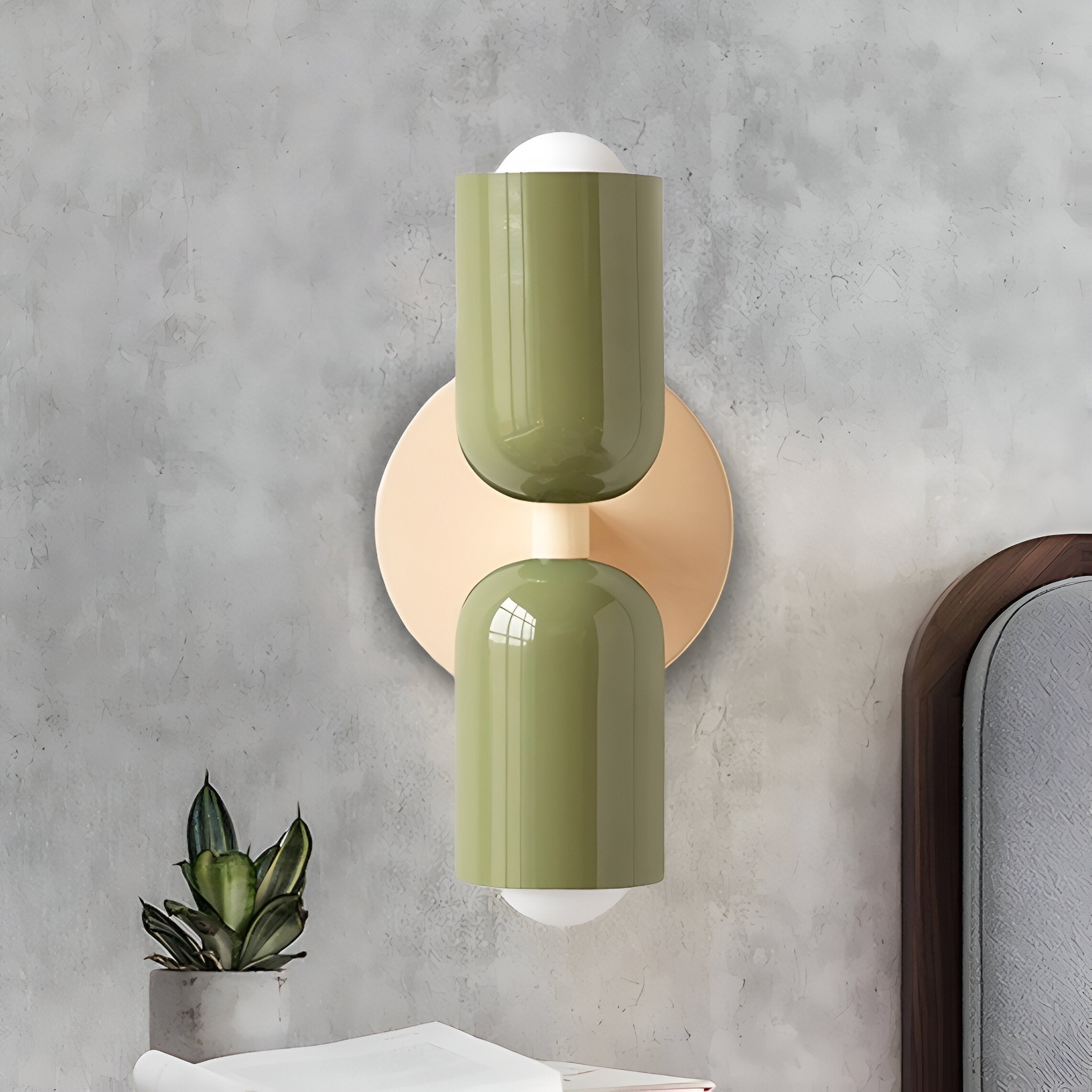 Green and pink double head wall light on a grey concrete wall