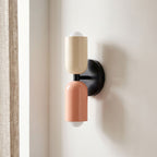 Two Tone Double Head Iron Wall Light on a plaster wall, angled view