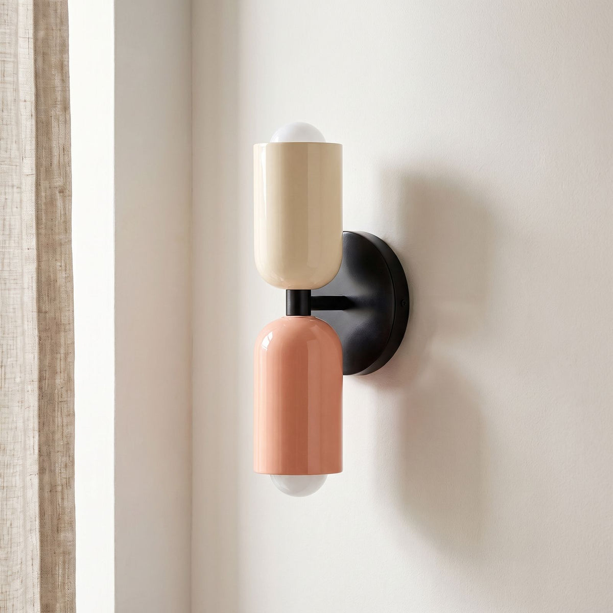 Two Tone Double Head Iron Wall Light on a plaster wall, angled view